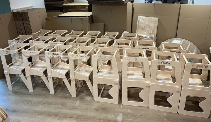 Torres de aprendizagem personalizadas com nomes e desenhos, alinhadas na oficina da Pokóto Wood, prontas a seguir para as famílias